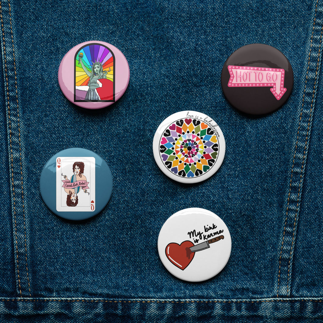 Photo shows 5 small pin back buttons on a jean jacket. The buttons feature various different colorful Chappell Roan-inspired designs.